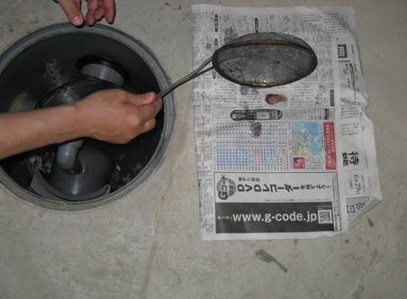 油や底に沈んだ細かいゴミを新聞紙に上げる写真
